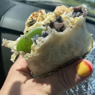 Chicken burrito with black beans, rice, vegetables, sour cream and guacamole