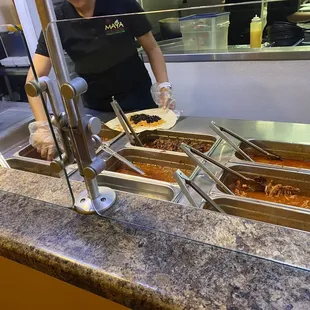 a woman preparing food in a buffet