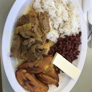 a plate of food with rice, beans, and meat