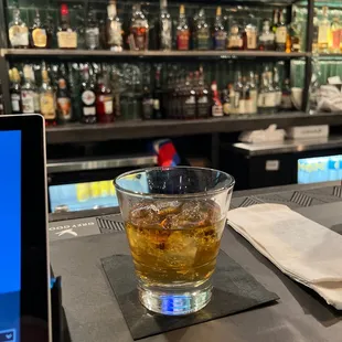 a glass of whiskey on a bar
