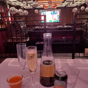 a table with two glasses of champagne and a bottle of wine