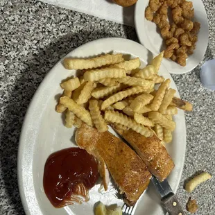 Broiled salmon steak with French fries and hush puppies, a small plate of fried baby shrimp