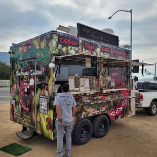 a man standing in front of a food truck