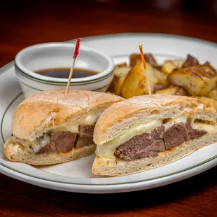a steak sandwich and potatoes