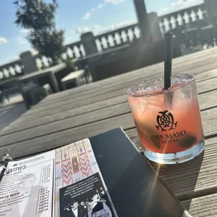 a drink and menu on a wooden table