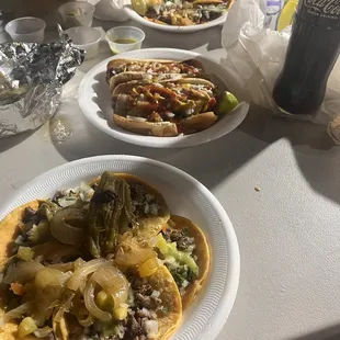 Mini asada tacos, Mexican hot dogs and pastor mini tacos with two cokes Mexicanas.