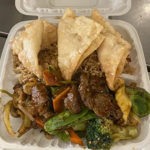 a takeout container with rice, meat, vegetables, and pita