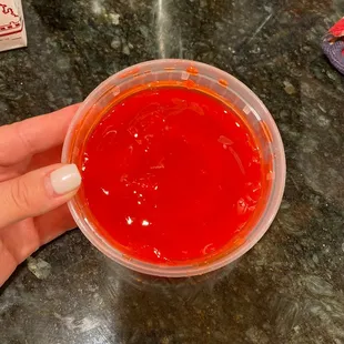 a person holding a cup of red liquid