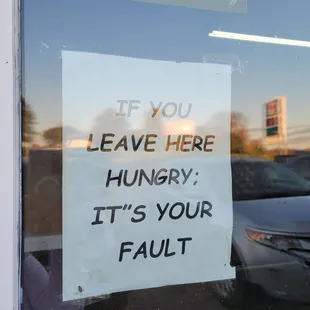 a sign in a window saying if you leave here hungry, it's your fault