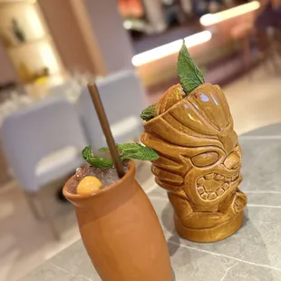 a tiki and a cocktail on a table