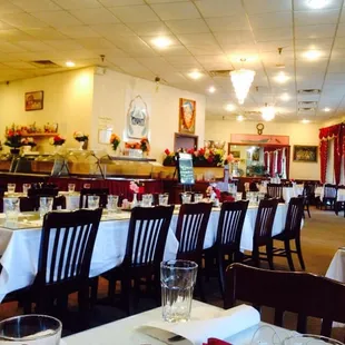 Another view of the other side of dining area! Love the comfortable chairs and white tablecloths with red real fabric napkins!