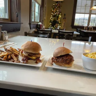 two plates of sandwiches and french fries