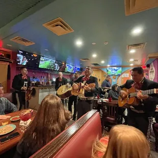 a group of people playing music in a mexican restaurant