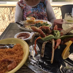 a woman sitting at a table with food
