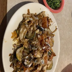 Grilled chicken with vegetables and rice covered in cheese dip  with a side of cilantro