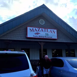 a man standing in front of a restaurant