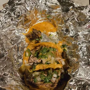 Street tacos trio, birria, carnival, steak (half eaten. Lol)