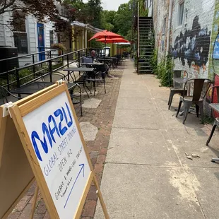 a sign on a sidewalk in front of a restaurant