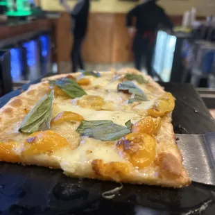 a slice of pizza on a black plate