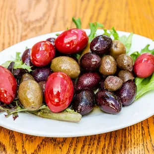 a plate of olives, tomatoes and lettuce