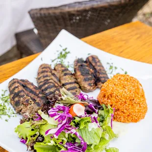 a plate of grilled meat and a salad