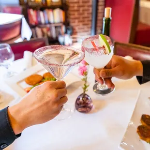 two people toasting at a restaurant table