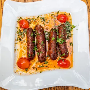 a plate of sausages and tomatoes