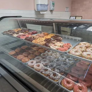 a variety of donuts in a display case
