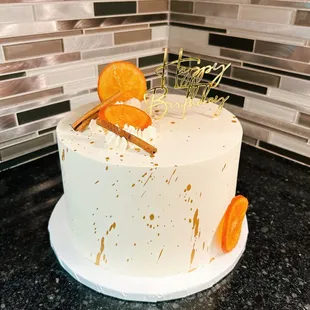 a white cake with oranges on top