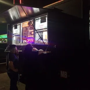 a group of people standing in front of a food truck