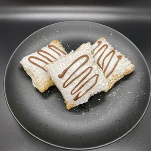 "Banana/Nutella puffs" Puff pastry filled with real banana slices and Nutella.  Dusted with a powdered sugar coating