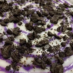 "Ube Crumble Panipopo" Freshly made ube bread rolls baked in a dreamy coconut sauce.  Then topped w/ube drizzle &amp; oreo cookie crumbles.