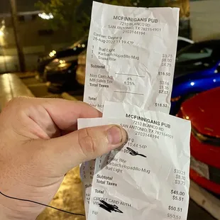 a hand holding a receipt