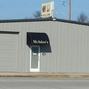 a gray building with a black awning