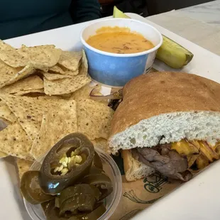 Nachos and a beef, horseradish, and cheese sandwich