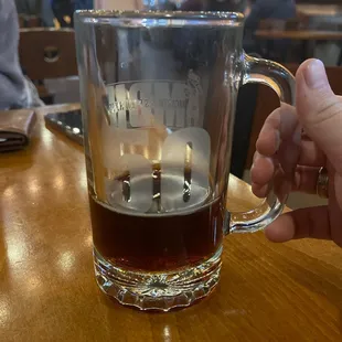 a person holding a mug of beer