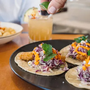 Ensenada Fish Tacos: beer-battered snapper, tomatillo salsa, chipotle aioli, cabbage lime slaw, queso fresco