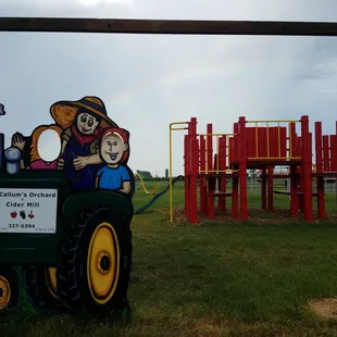 a tractor with a rainbow in the background