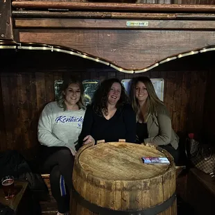 three women sitting in a barrel