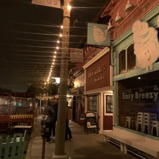 people walking down a sidewalk at night
