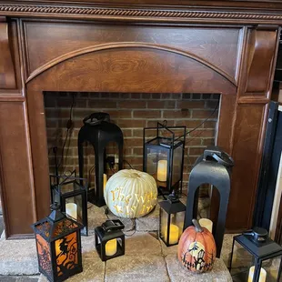 a fire place with pumpkins and lanterns