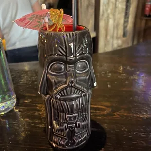 a tiki with a straw and umbrella