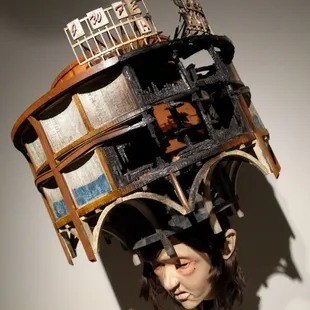 Umm . . .  Trying to make sense out of this - a man with a runny nose wearing s partially torched structure atop his head