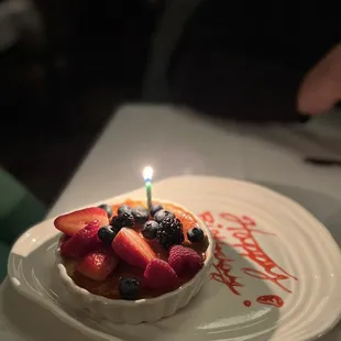 a birthday cake with strawberries and blueberries