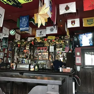 a bar with flags hanging from the ceiling