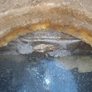 Corroded opening and divider wall inside tank before repair