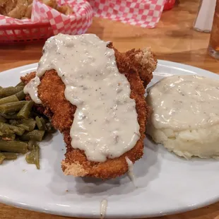 Chicken Fried Chicken with mashed potatoes, gravy and green beans.