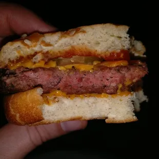 a hand holding a hamburger