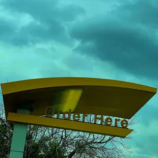 a large yellow sign with a sky background