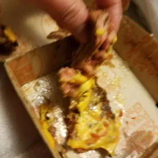 a hand picking up a piece of pizza